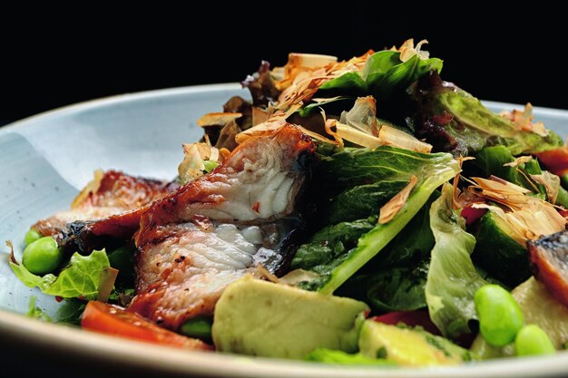 Salade d'anguille grillée et de légumes sur une assiette