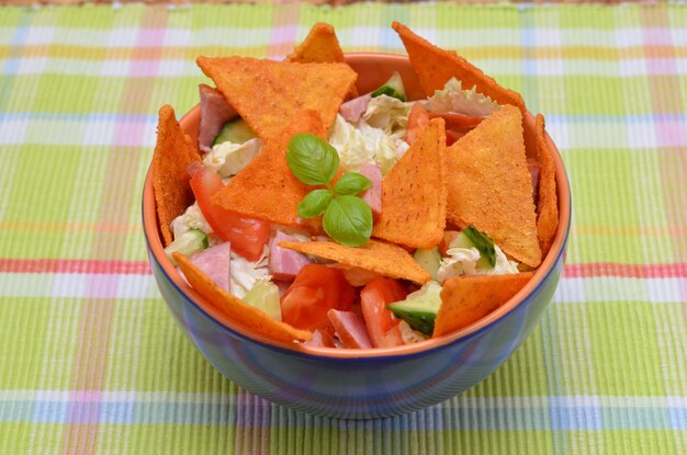 Salade appétissante avec légumes et frites mexicaines dans un bol gros plan