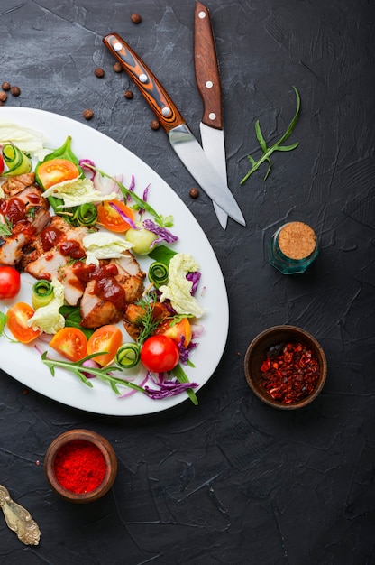 Salade appétissante avec tomate, concombre, laitue et steak de viande. Steak grillé en tranches