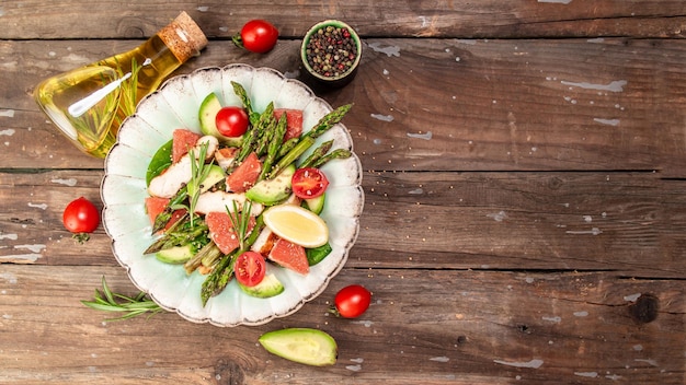 Salade d'asperges pamplemousse tomates cerises avocat filet de poulet épinards dans un bol vue de dessus espace format bannière longue pour le texte