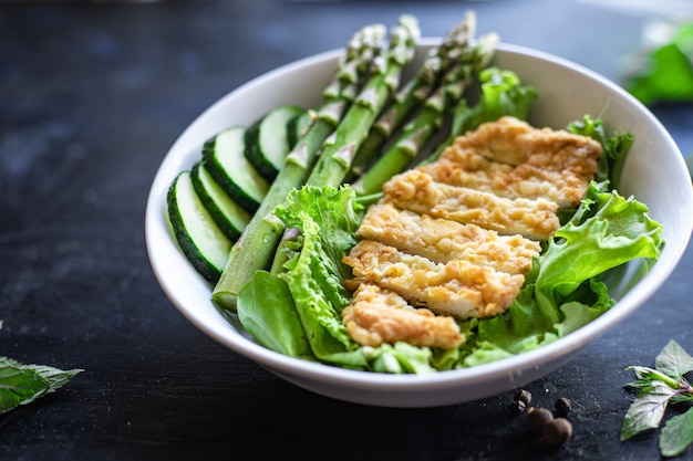 Salade d'asperges vertes bol de viande de poulet feuilles de salade vertes mangeant un régime biologique sur la table