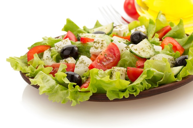 Salade en assiette isolé sur blanc