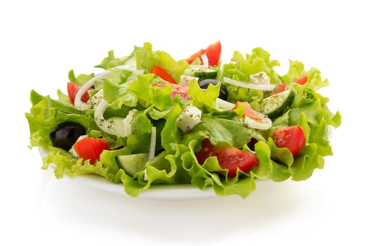 Photo salade en assiette isolé sur blanc