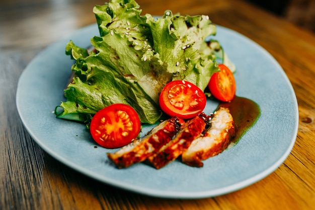 Salade au poulet et tomates sur l&#39;assiette.