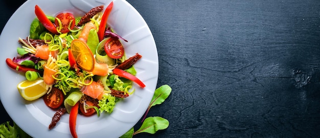 Salade au saumon et légumes frais et herbes Cuisine italienne Vue de dessus Sur fond de bois