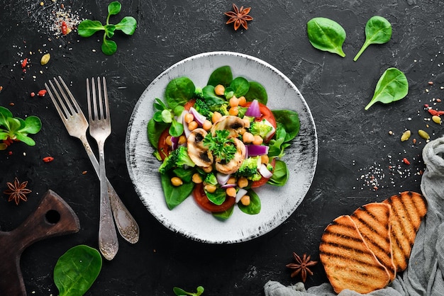 Salade aux champignons épinards pois turcs et oignons dans une assiette sur un fond en bois Vue de dessus Espace libre pour votre texte Mise à plat