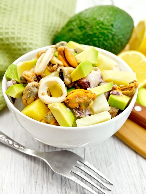 Salade aux fruits de mer et avocat dans un bol sur tableau blanc