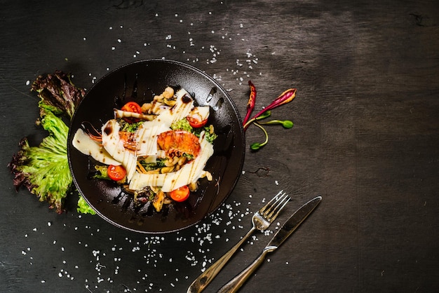 Une salade aux grosses crevettes et légumes sur fond noir