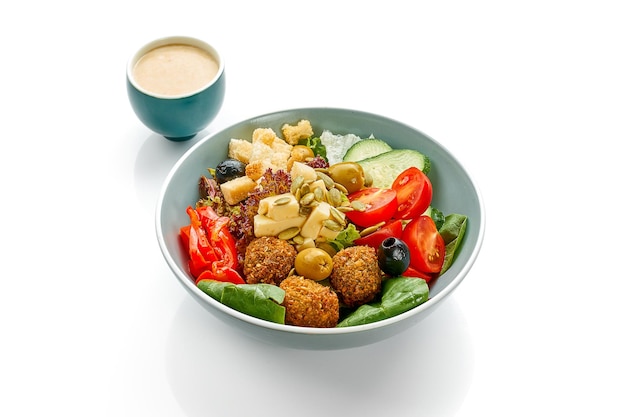 Salade aux olives falafel et tomates dans un bol sur fond blanc