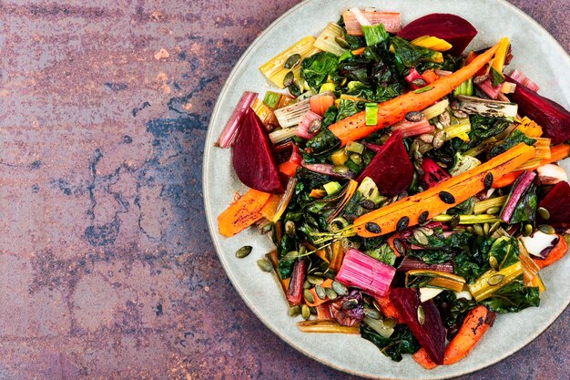 Salade de betterave cuite et de carottes sur une table de cuisine en béton Salade de betterave cuite avec des légumes