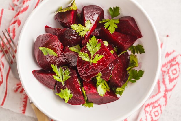 Salade de betteraves au four avec du persil et de l&#39;huile dans un bol blanc.