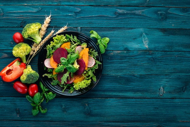 Salade de betteraves fraîches, tomates et laitue Alimentation saine Sur une table en bois bleue Vue de dessus Espace libre pour le texte
