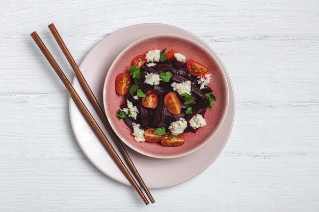 Salade de betteraves maison dans un bol avec des noix, de la mozzarella, du persil et des tomates cerises. Concept de nourriture végétalienne