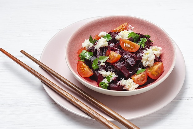 Salade de betteraves maison dans un bol avec des noix, de la mozzarella, du persil et des tomates cerises. Concept de nourriture végétalienne