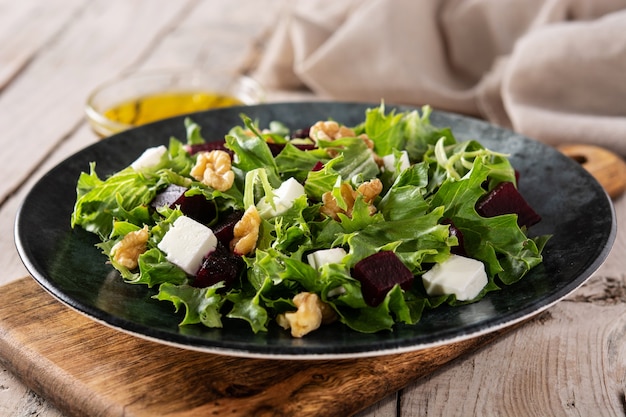 Salade de betteraves rouges au fromage feta, laitue et noix sur une table en bois rustique