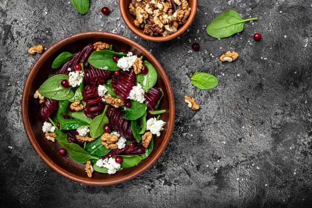 Salade de betteraves saines avec des bébés épinards frais et des canneberges au fromage et aux noix