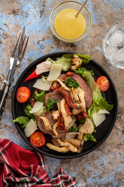 Salade de boeuf tiède aux pleurotes, tomates et légumes verts. Vue de dessus