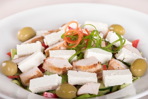 Salade Caeser avec filet de poulet, assiette blanche