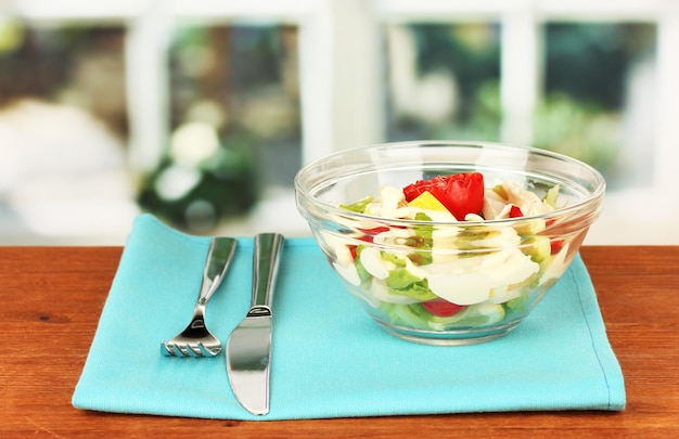 Salade de calmars aux légumes dans un bol en verre sur une table en bois libre