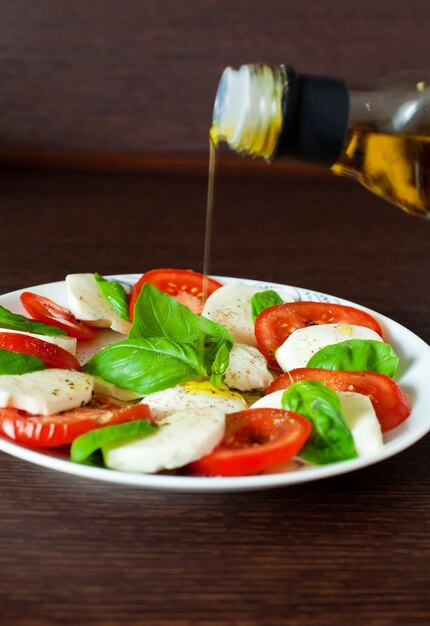 Photo salade caprese avec coulée d'huile d'olive