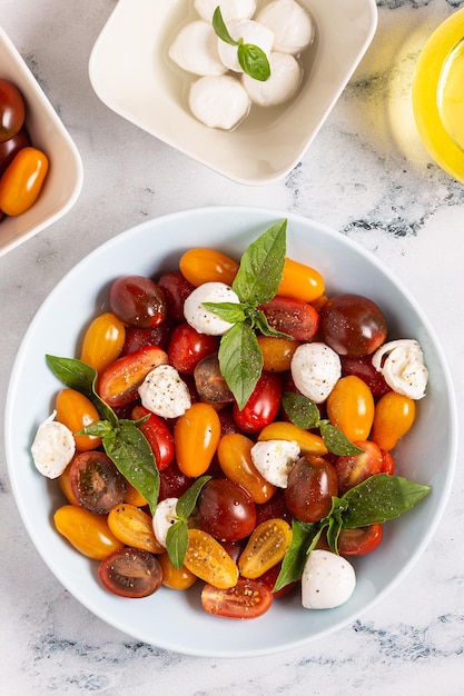 Salade caprese italienne aux tomates, fromage mozzarella, basilic, huile d'olive, vue de dessus.