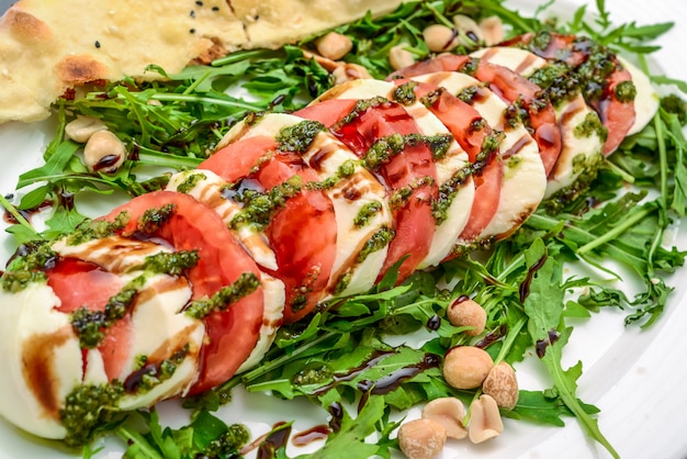 Salade caprese italienne traditionnelle avec sauce au pesto basilic