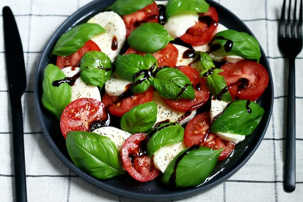 Salade caprese signature italienne sur une assiette noire
