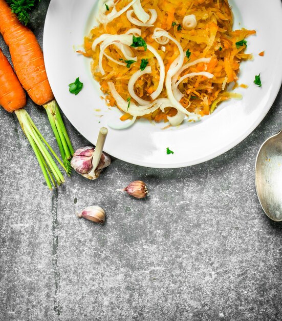 Salade de carottes aux épices. Sur fond rustique.