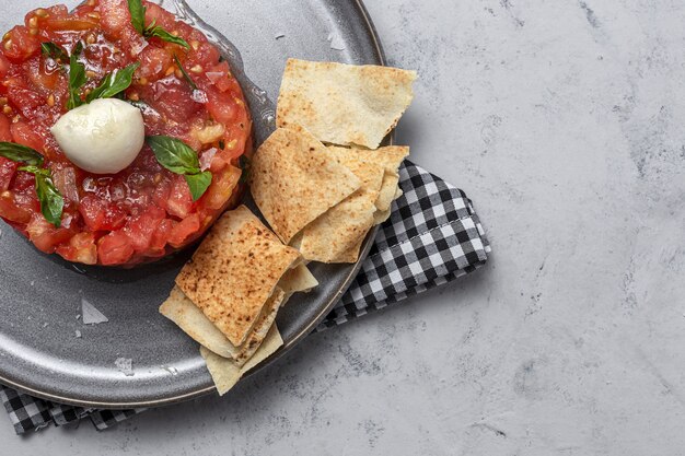 Salade de carpaccio de tomates maison avec mozzarella, huile d'olive et basilic avec pain arabe