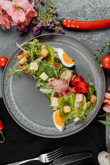 Salade César sur une assiette grise avec décor et copyspace