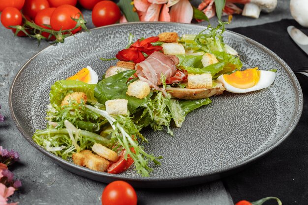 Salade César sur une assiette grise avec décor et copyspace