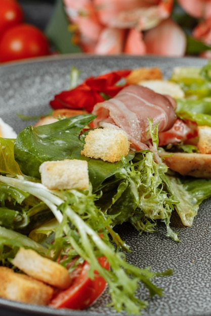 Salade César sur une assiette grise avec décor