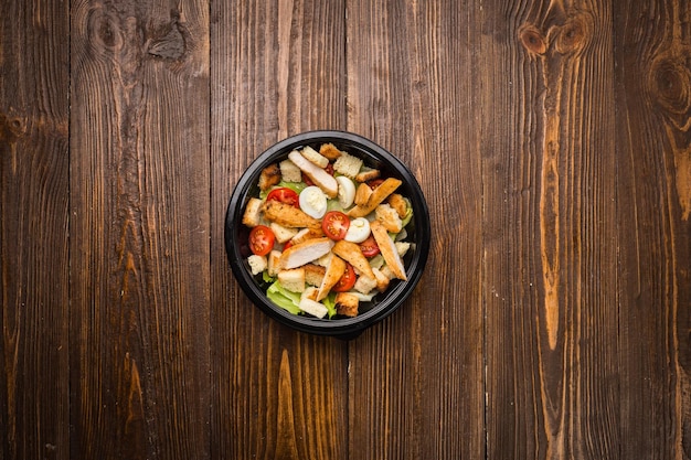 Salade césar au poulet tomates cerises et œufs de caille sur une assiette