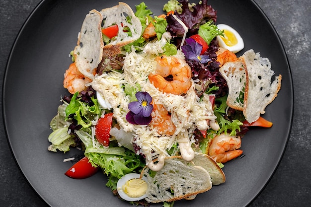 Salade César aux crevettes sur fond noir