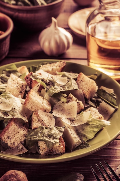 Salade César et ingrédients au fond en bois