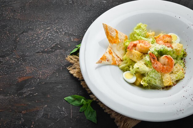 Salade César de légumes aux crevettes Dans l'assiette Vue de dessus Espace libre pour votre texte Style rustique