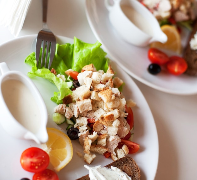 Salade césar traditionnelle avec saucière et pain