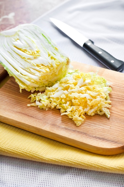 Salade de chou chinois, de maïs sucré et de surimi - la moitié du chou chinois sur une planche à découper en bois.