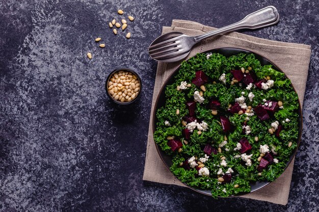 Salade de chou frisé et de betteraves crues saines avec fromage feta et pignons de pin. Vue de dessus.