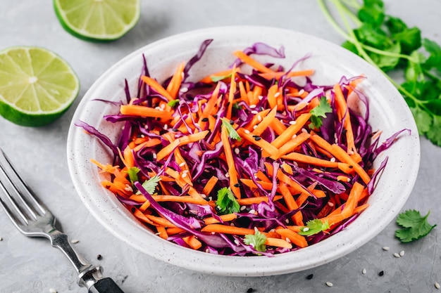 Salade de chou rouge et de carottes avec coriandre et graines de sésame sur fond de pierre