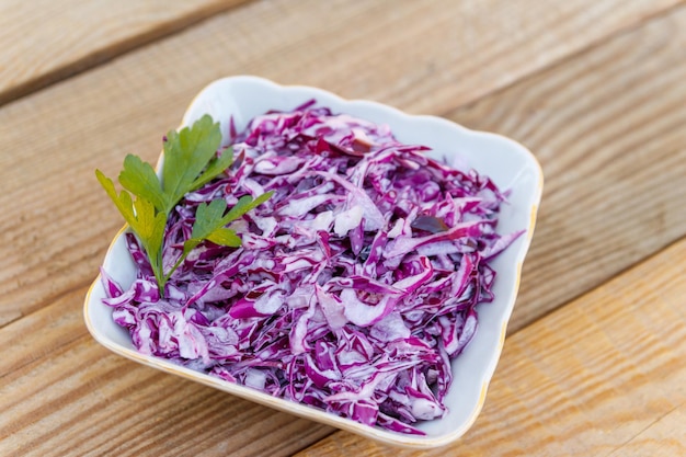 Salade de chou rouge avec oignon et mayonnaise sur table en bois