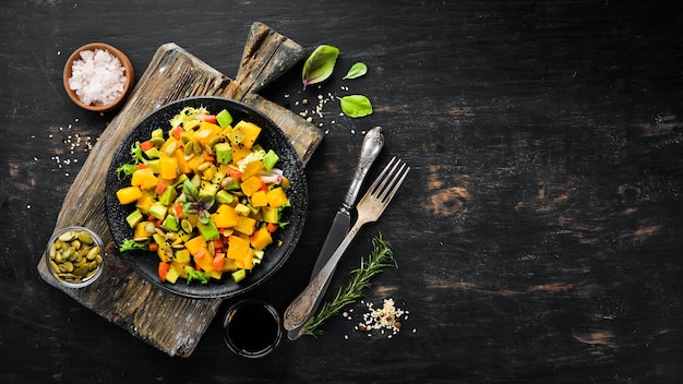 Salade de citrouille avocat et graines de citrouille Sur fond noir Vue de dessus Espace libre pour votre texte