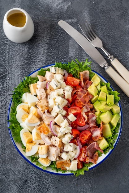 Salade Cobb au poulet frit avocat tomates fraîches oeufs bacon et fromage mise au point sélective