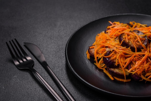 Salade coréenne aux aubergines carottes ail épices et herbes sur fond de béton foncé