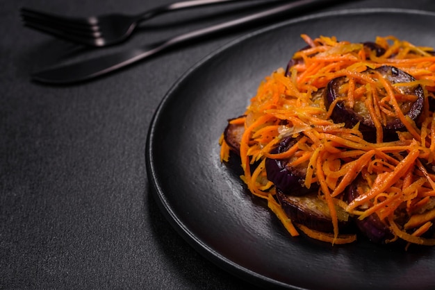 Salade coréenne aux aubergines carottes ail épices et herbes sur fond de béton foncé