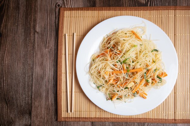 Salade coréenne de funchosa aux crevettes sur une serviette en bambou