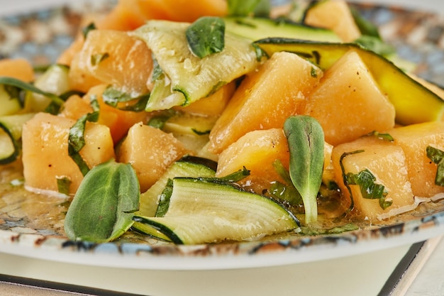 Salade de courgettes melon et herbes sur marbre blanc