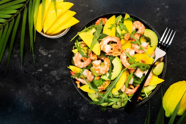 Salade de crevettes à la mangue et à l'avocat avec épinards aux noix et roquette Saine alimentation concept alimentaire Vue de dessus fond gris