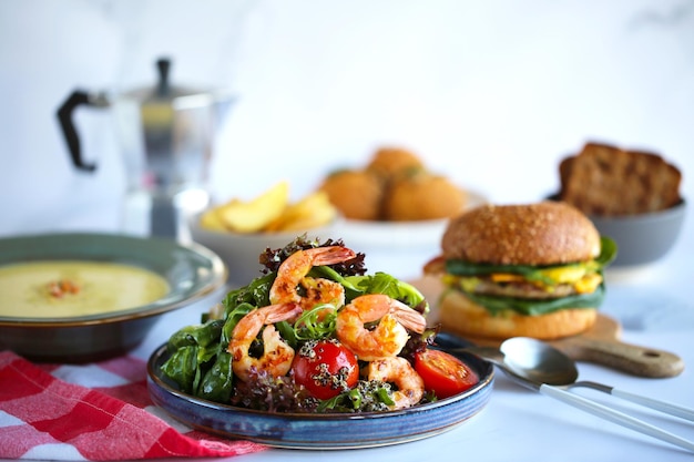 Salade de crevettes et quinoa Belle salade savoureuse.Beaucoup de nourriture sur la table, déjeuner.Une bonne nutrition.Salade, hamburger et soupe. Jour de repas.Belle nourriture savoureuse.Salade au quinoa.Table de fête.Crevettes grillées