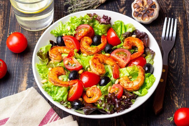 Photo salade avec des crevettes, des tomates, des olives et des noix manger sainement